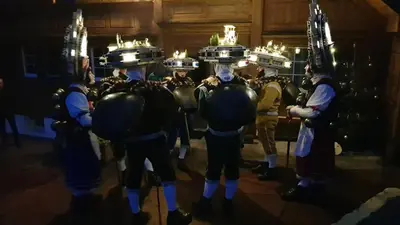 a group of men in uniforms with torches on their heads at Mällis Heimetli in Urnäsch