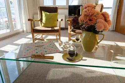 a glass coffee table with a vase of flowers and a chess board at Eldanora in Wildhaus