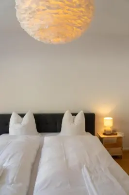 a bedroom with a white bed with a painting above it at Saentis in Wildhaus