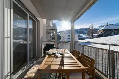 a wooden table on a balcony with a view at Saentis in Wildhaus