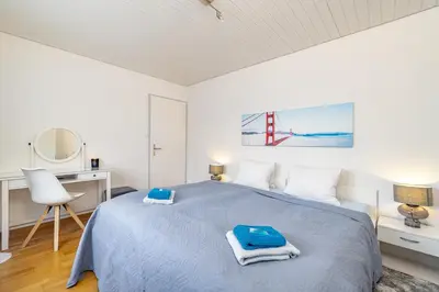 a bedroom with a bed and a desk and a mirror at Ferienwohnung mit Balkon W7 in St. Gallen