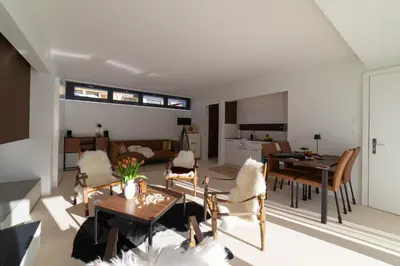 a living room with a table and chairs and a kitchen at Alpstein in Wildhaus
