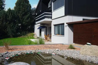 a house with a pond in front of a building at Alpstein in Wildhaus