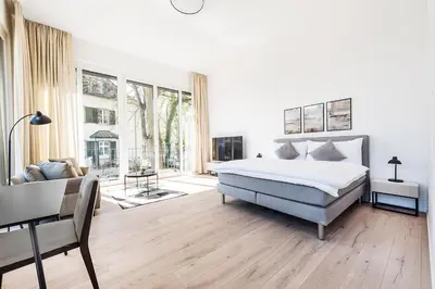 a white bedroom with a bed and a couch at DESIGN-STUDIO 4 !Gratis Parken, Free Parking! in Kreuzlingen