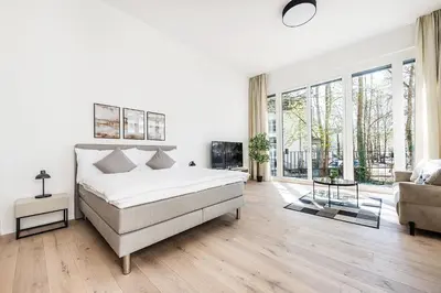 a white bedroom with a bed and a couch at DESIGN-STUDIO 2 !Gratis Parken, Free Parking! in Kreuzlingen
