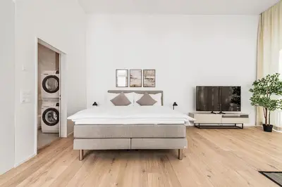 a white bedroom with a bed and a flat screen tv at DESIGN-STUDIO 2 !Gratis Parken, Free Parking! in Kreuzlingen