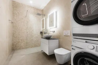 a bathroom with a sink and a washing machine at DESIGN-STUDIO 1 !Gratis Parken, Free Parking! in Kreuzlingen