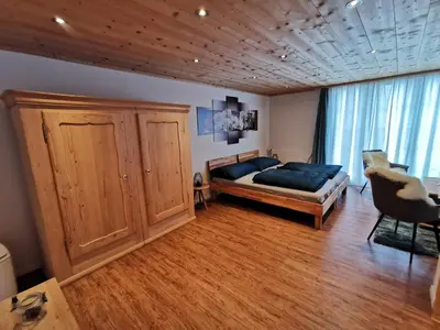 a bedroom with a bed and a large window at Strickerhof in Hundwil