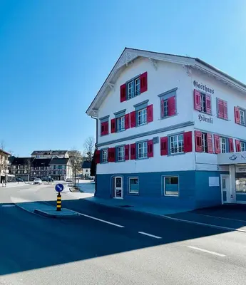 a blue and white building with red windows on a street at Appartement Hörnli Seeliebe in Kreuzlingen
