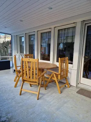 a wooden table and chairs on a porch at Chalet Thur in Unterwasser