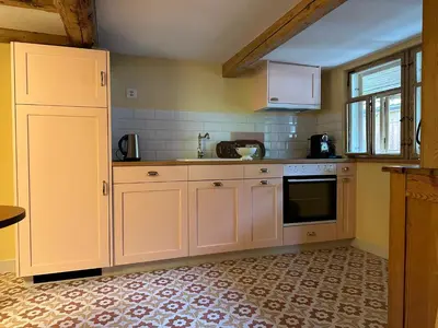 a kitchen with white cabinets and a sink at Historic Swiss Room in Guesthouse Rosalie in Brunnadern