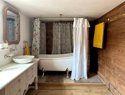 a bathroom with a tub and a sink and a shower at Historic Swiss Room in Guesthouse Rosalie in Brunnadern