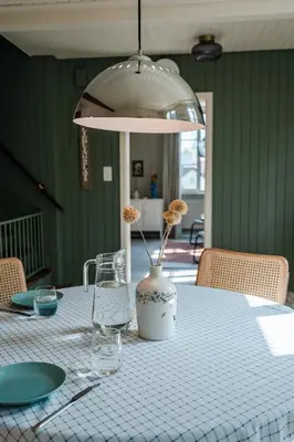 a table with a white vase with flowers in it at Kaffeegasse 11 - Holiday home with heart on Lake Constance in Altnau
