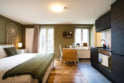 a bedroom with a bed and a desk and a kitchen at Klara 0002 - Olma, Spital, Uni St- Gallen in St. Gallen