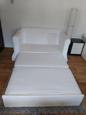 a white couch sitting in a living room at schickes gemütliches Studio in Bühler