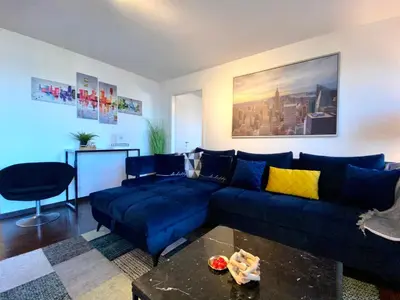 a living room with a blue couch and a table at Modern Lakeview Apartment in Romanshorn