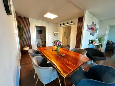 a wooden table and chairs in a living room at Modern Lakeview Apartment in Romanshorn