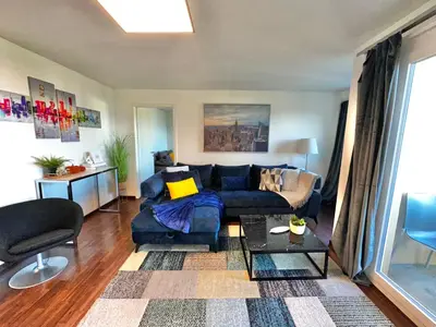 a living room with a blue couch and a table at Modern Lakeview Apartment in Romanshorn