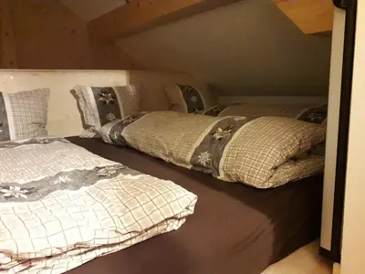 two beds are sitting in a room with at Haus Ritzlisjokes in Weissbad