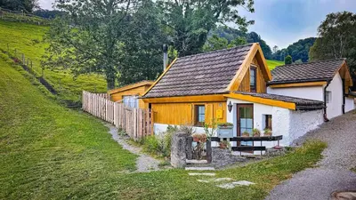 a small yellow and white house on a hill at Zum Wöschhüsli mit Sauna in Rheineck