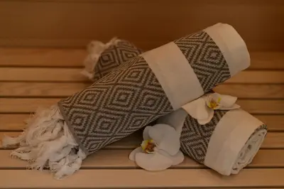 a pile of towels and white flowers on a bed at S-Cape Suite&Spa in Horn
