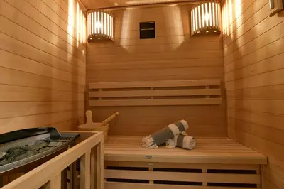a sauna with a teddy bear sitting on a wooden bench at S-Cape Suite&Spa in Horn