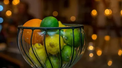 a glass bowl filled with oranges and limes at Hotel Badhof in Altstätten