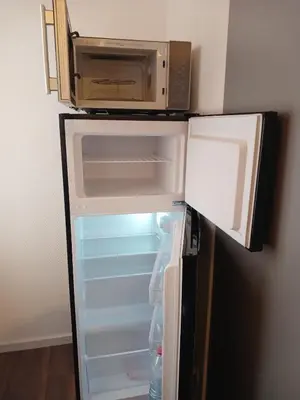 an open refrigerator with a microwave on top of it at 2,5 Zimmer Ferienwohnung in Bühler, Nähe Appenzell in Bühler