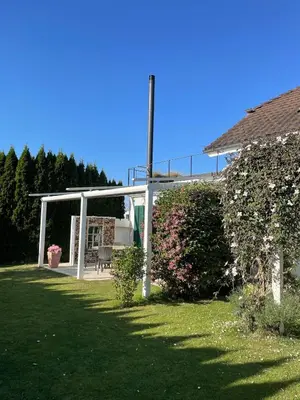 a white pergola in the yard of a house at Traumwohnung in 3 Minuten zum Bodensee in Dozwil