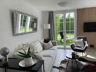 a living room with a couch and a chair at Traumwohnung in 3 Minuten zum Bodensee in Dozwil