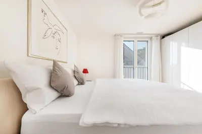 a white bedroom with a white bed and a window at DESIGN-APARTMENT 2 !Gratis parken, Free Parking! in Kreuzlingen