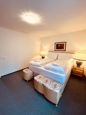 a bedroom with a bed with two ottomans at Gemütliches und geräumiges Apartment für Familien und Gruppen mit Seeblick in Heiden