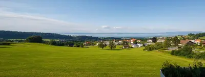 a green field with a town in the distance at Park in Heiden
