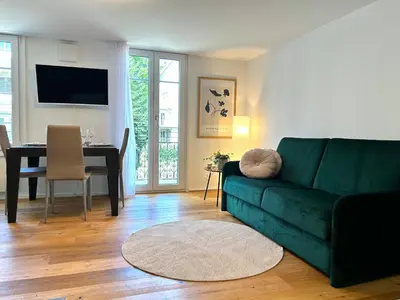 a living room with a green couch and a table at Klara 1011 - Olma, Spital, Uni St- Gallen in St. Gallen