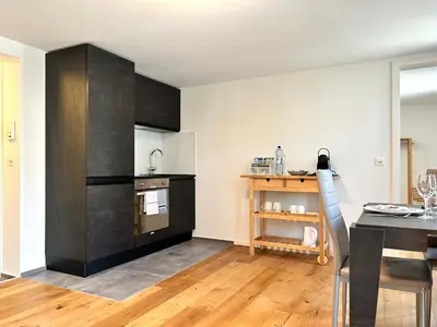 a kitchen with black cabinets and a table with a dining room at Klara 1011 - Olma, Spital, Uni St- Gallen in St. Gallen