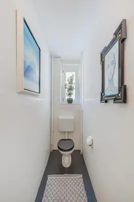 a bathroom with a toilet and a picture on the wall at Zimmer mit Gemeinschaftsbad in Arbon