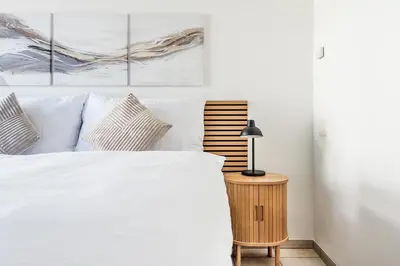 a bedroom with a white bed and two paintings at CITY HOUSE !Gratis Parken, Free Parking! in Kreuzlingen