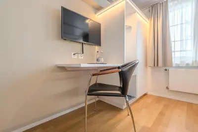 a chair in a room with a desk and a tv at Gasthaus zur Sonne - Hotel - Restaurant - Boutique in Gossau