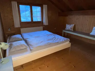 a bedroom with a bed with blue sheets and a window at Modern trifft Tradition in Grabs