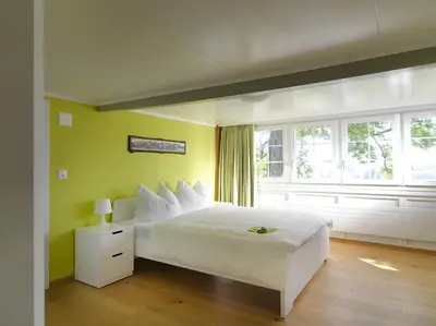 a bedroom with a white bed and a window at Hotel B&BAlpenheim in Teufen