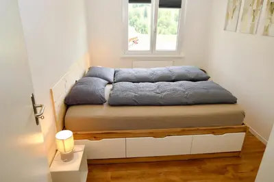 a bed in a room with a window at Ferienwohnung Panoramablick in Nesslau