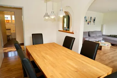 a dining room with a wooden table and black chairs at Ferienwohnung Panoramablick in Nesslau
