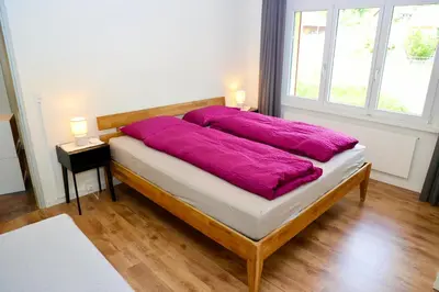 a bed with a purple blanket on it in a room at Ferienwohnung Panoramablick in Nesslau