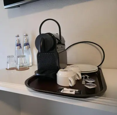a tray with a tea pot and cups on a counter at Hotel Salvi in Kreuzlingen