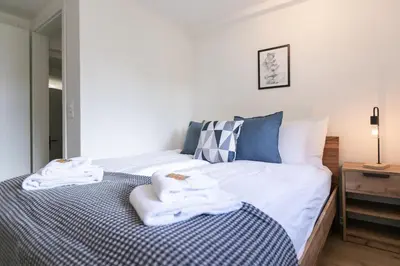 a bedroom with a bed with towels on it at book2stay - Apartments Spisertor in St. Gallen