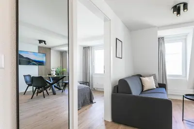 a mirror in a living room with a couch and a table at book2stay - Apartments Spisertor in St. Gallen