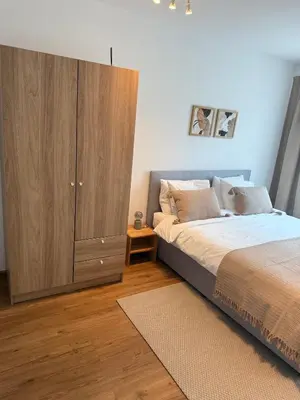 a bedroom with a large bed and a wooden cabinet at Studio mit Balkon im Zentrum in St. Gallen