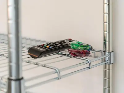 a remote control sitting on a metal shelf at WYBA Living - Modernes Apartment - Gratis ÖV - Ruhig & Zentral in St. Gallen