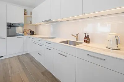 a white kitchen with white cabinets and a sink at BLIV Design-Apartment mit Parkplatz, nahe Zentrum in St. Gallen