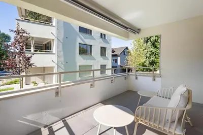 a balcony with a chair and a table and two windows at BLIV Design-Apartment mit Parkplatz, nahe Zentrum in St. Gallen